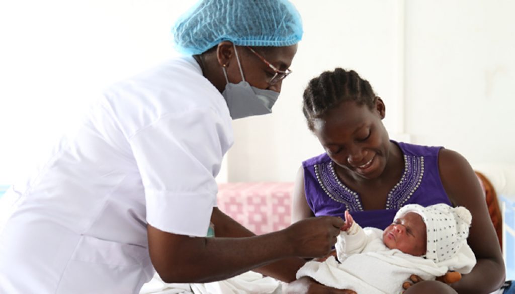 Cameroonian midwife caring for a mother and newborn